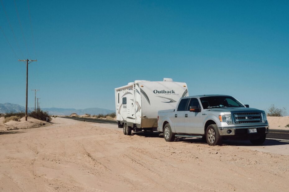 A travel trailer being safely and stably towed on a scenic highway, showcasing the confidence and control provided by a quality sway control system for RV travel.