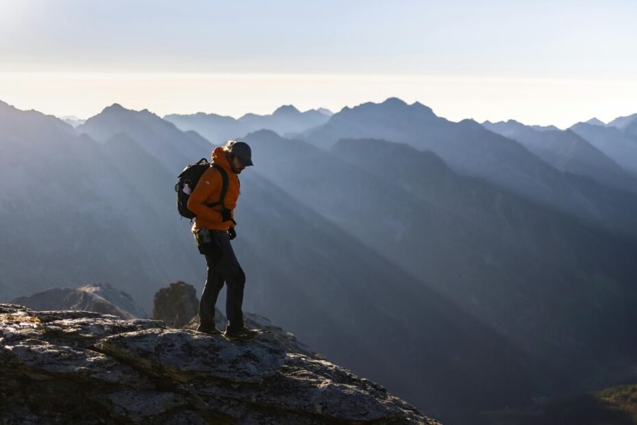 A solo traveler standing on a viewpoint and looking out over a beautiful landscape at sunrise, symbolizing the freedom and self-discovery of a solo travel adventure.