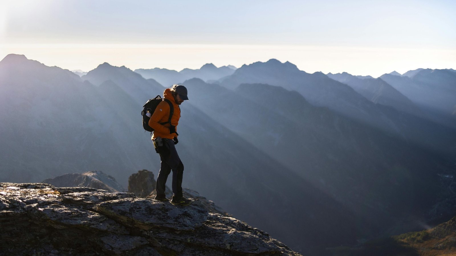 A solo traveler standing on a viewpoint and looking out over a beautiful landscape at sunrise, symbolizing the freedom and self-discovery of a solo travel adventure.