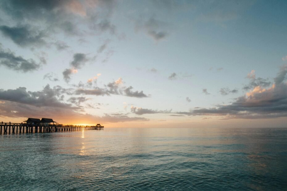 A serene, wide view of the sun rising over a sandy shore, illustrating one of the best beaches in Texas for a Gulf Coast vacation.