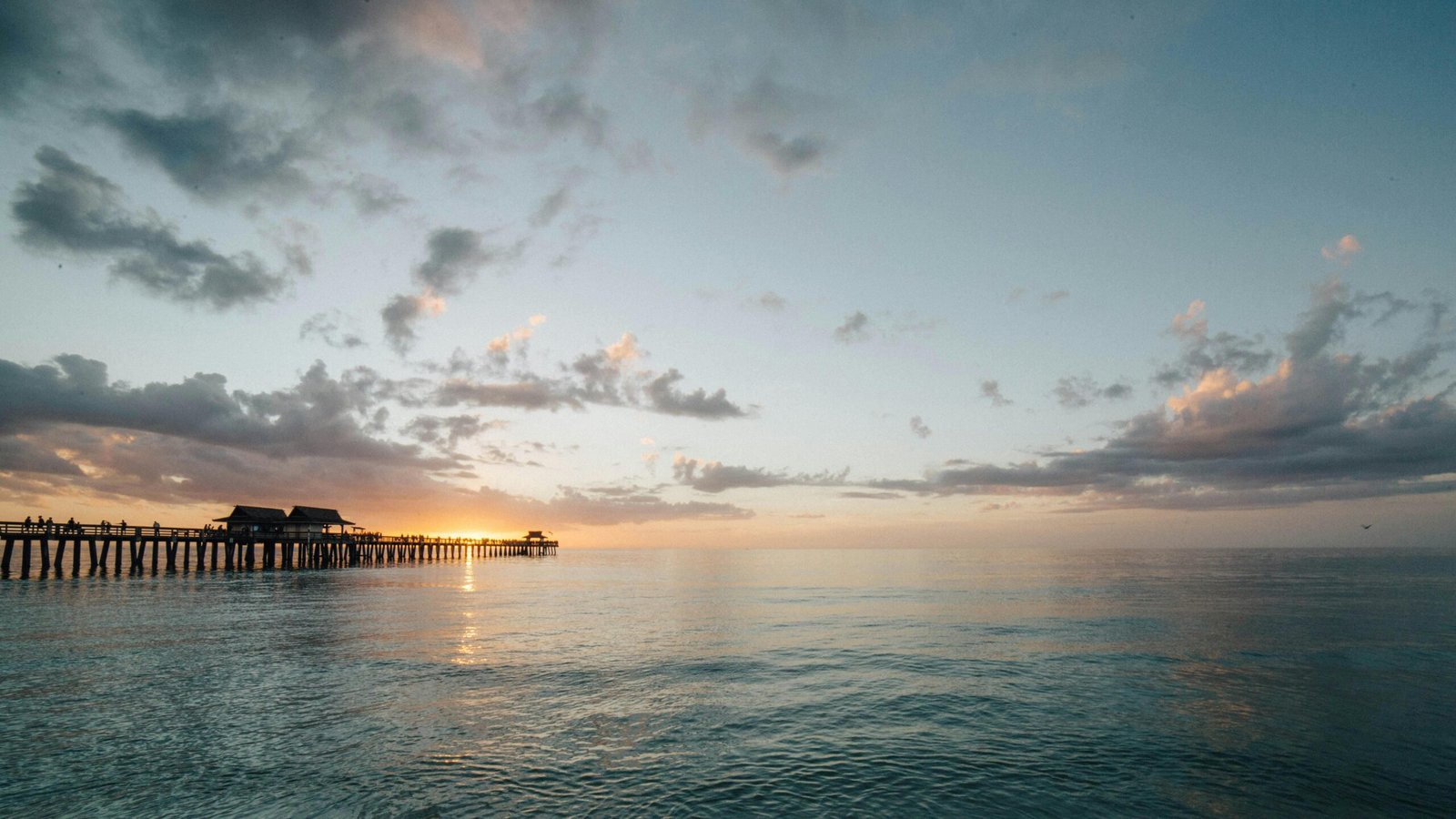A serene, wide view of the sun rising over a sandy shore, illustrating one of the best beaches in Texas for a Gulf Coast vacation.