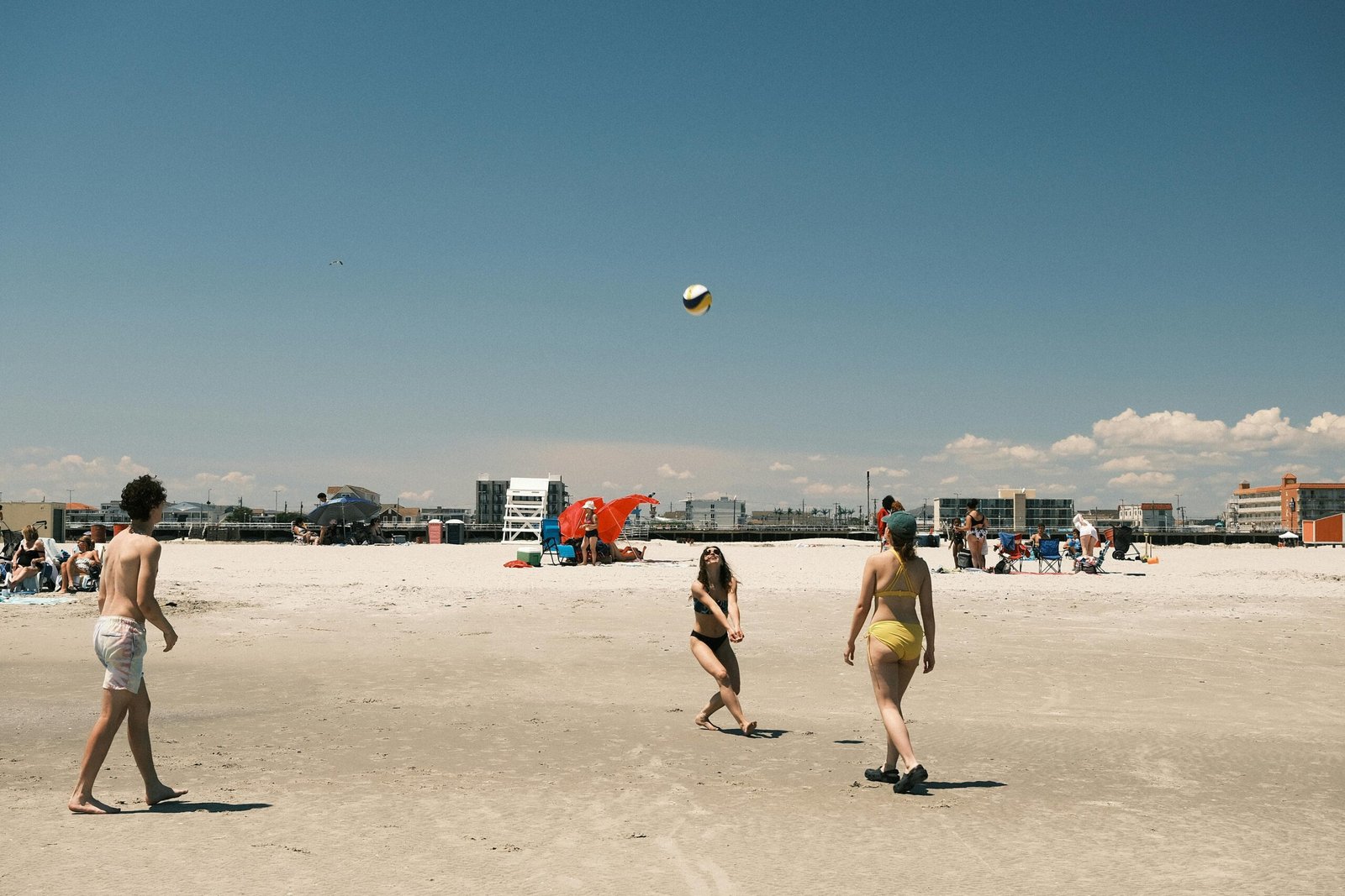 A scenic view of one of the best beaches in New Jersey on a sunny day, with waves from the Atlantic Ocean washing up on the sandy shore.