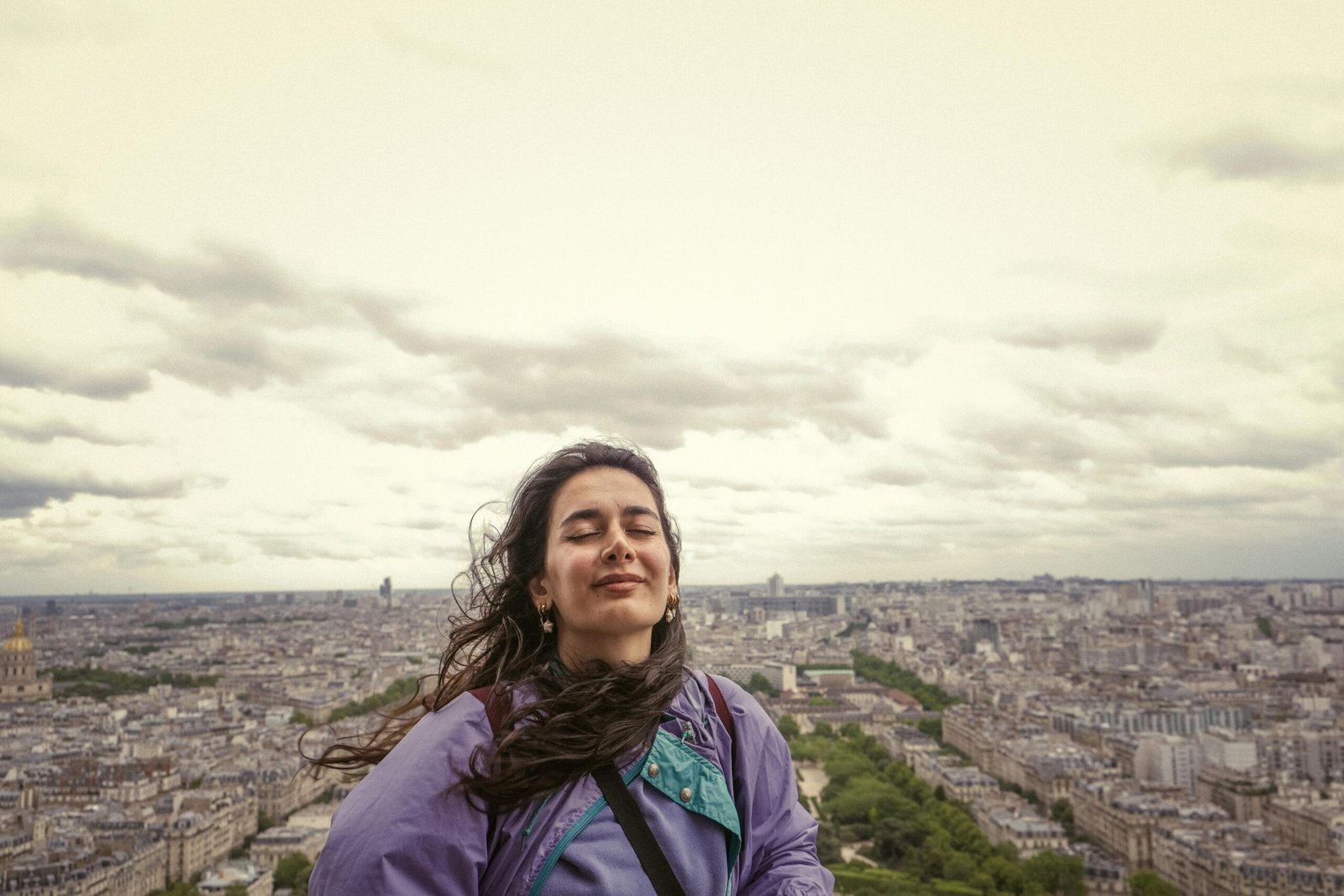 Solo female traveler enjoying a scenic panoramic view of a beautiful historic European city, symbolizing freedom, safe independent travel, and adventure in Europe.