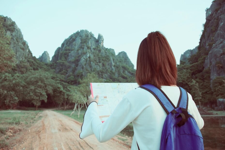 A backpacker consults a map in a scenic location, planning their next destination on a low cost foreign tour.