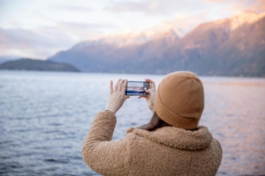 A person planning one of the best day trips Reddit recommends on their smartphone with a beautiful landscape in the background.