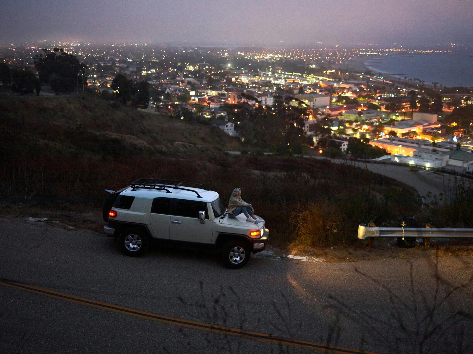 A traveler enjoying a scenic mountain view, illustrating one of the many cheap places in the USA to visit on a budget-friendly road trip.