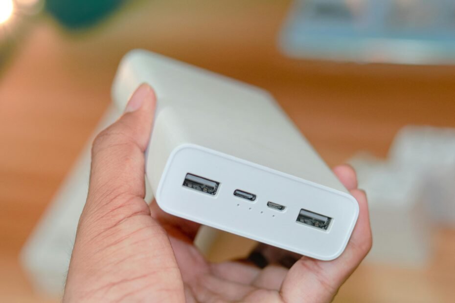 Universal MX travel adapter with USB ports charging a phone and laptop, essential for safe electronics power and connectivity in Mexico.