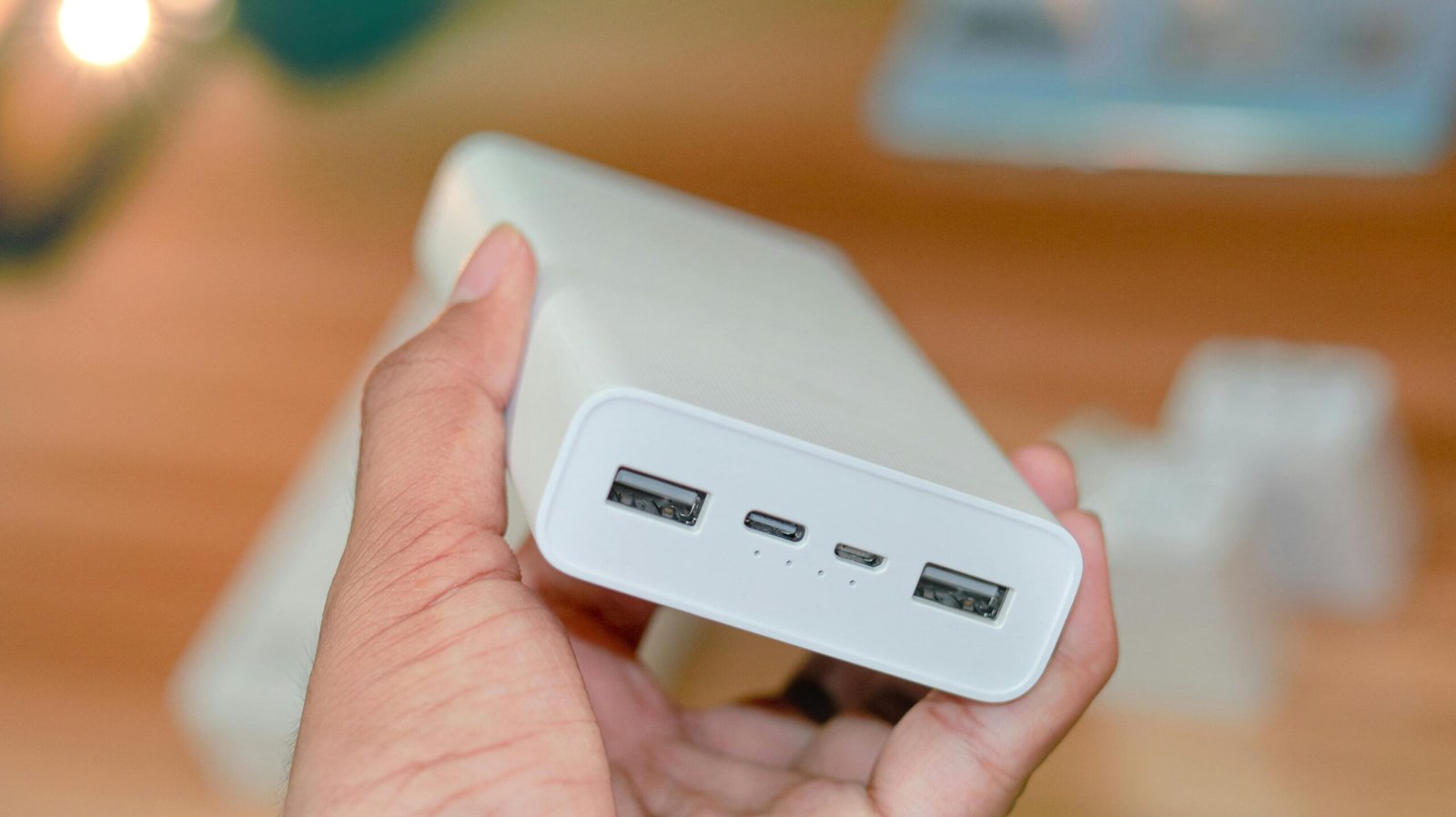 Universal MX travel adapter with USB ports charging a phone and laptop, essential for safe electronics power and connectivity in Mexico.