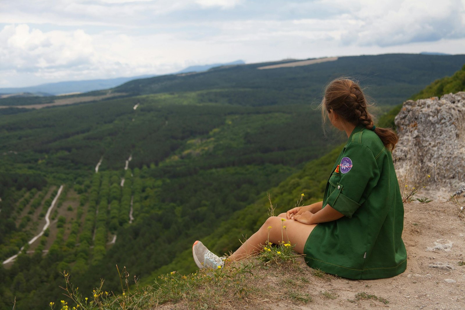 A traveler looking out over a vibrant, sunny landscape, an ideal example of one of the best places to travel in May.