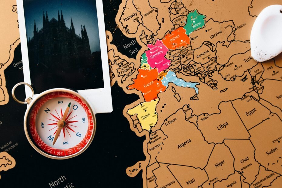 A travel flat lay with a map of Europe, a passport, and a camera, representing the planning process for a trip to the top European cities to see.