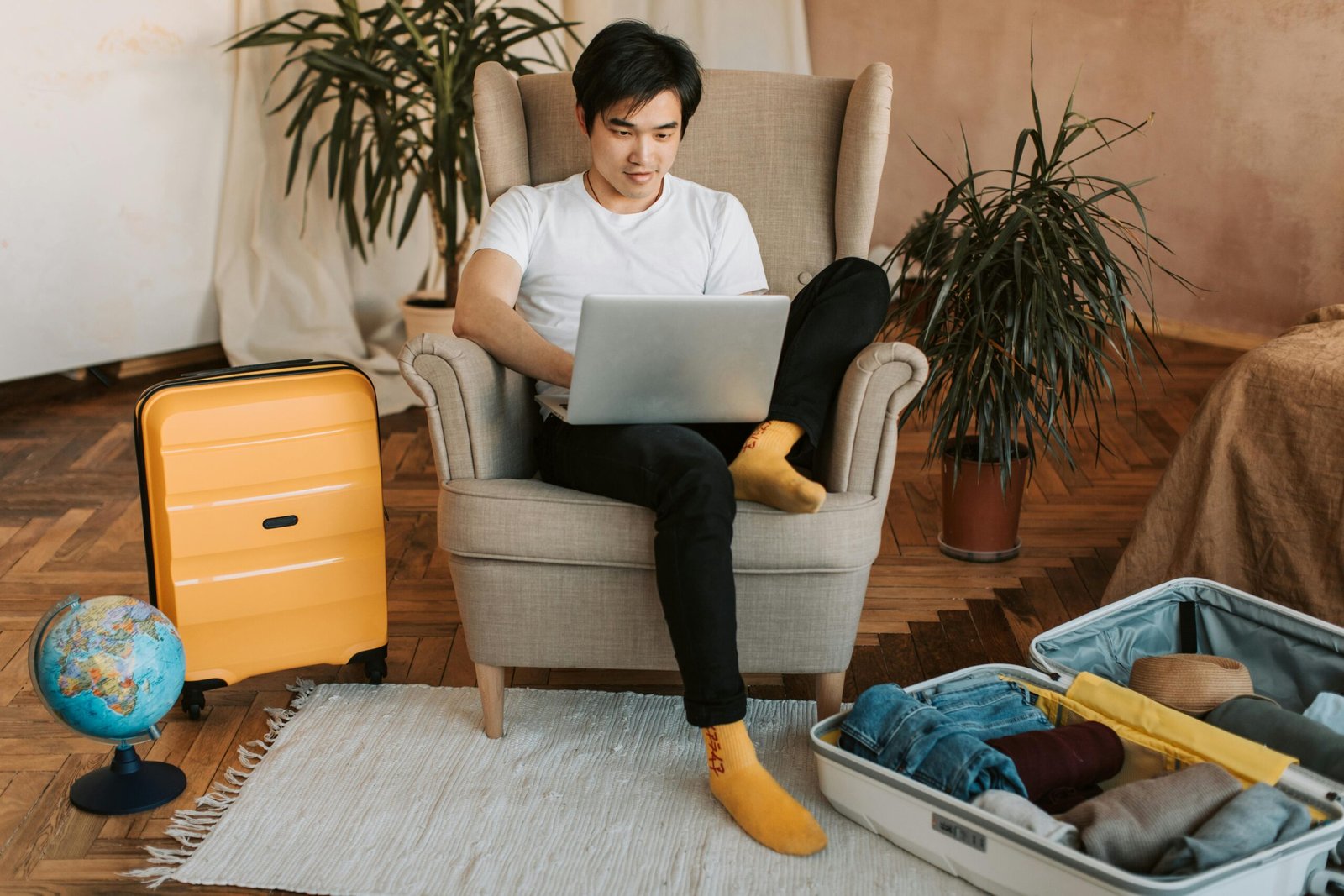 A person smiling while using a laptop to plan their vacation by comparing the top travel sites for 2025.