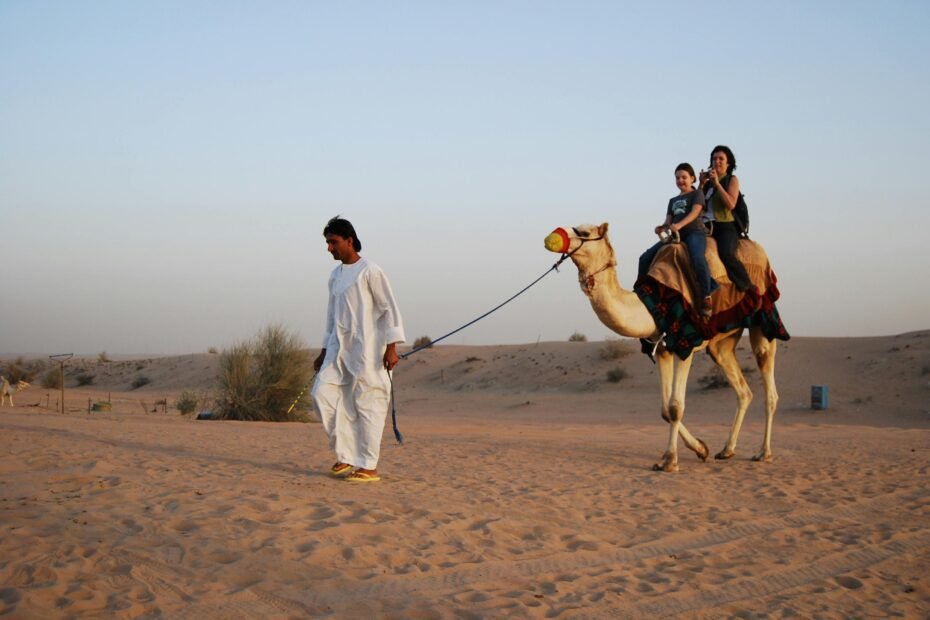 Golden dunes of Dubai desert safari at sunset, featuring camel riding and traditional experiences, capturing adventure and cultural immersion.