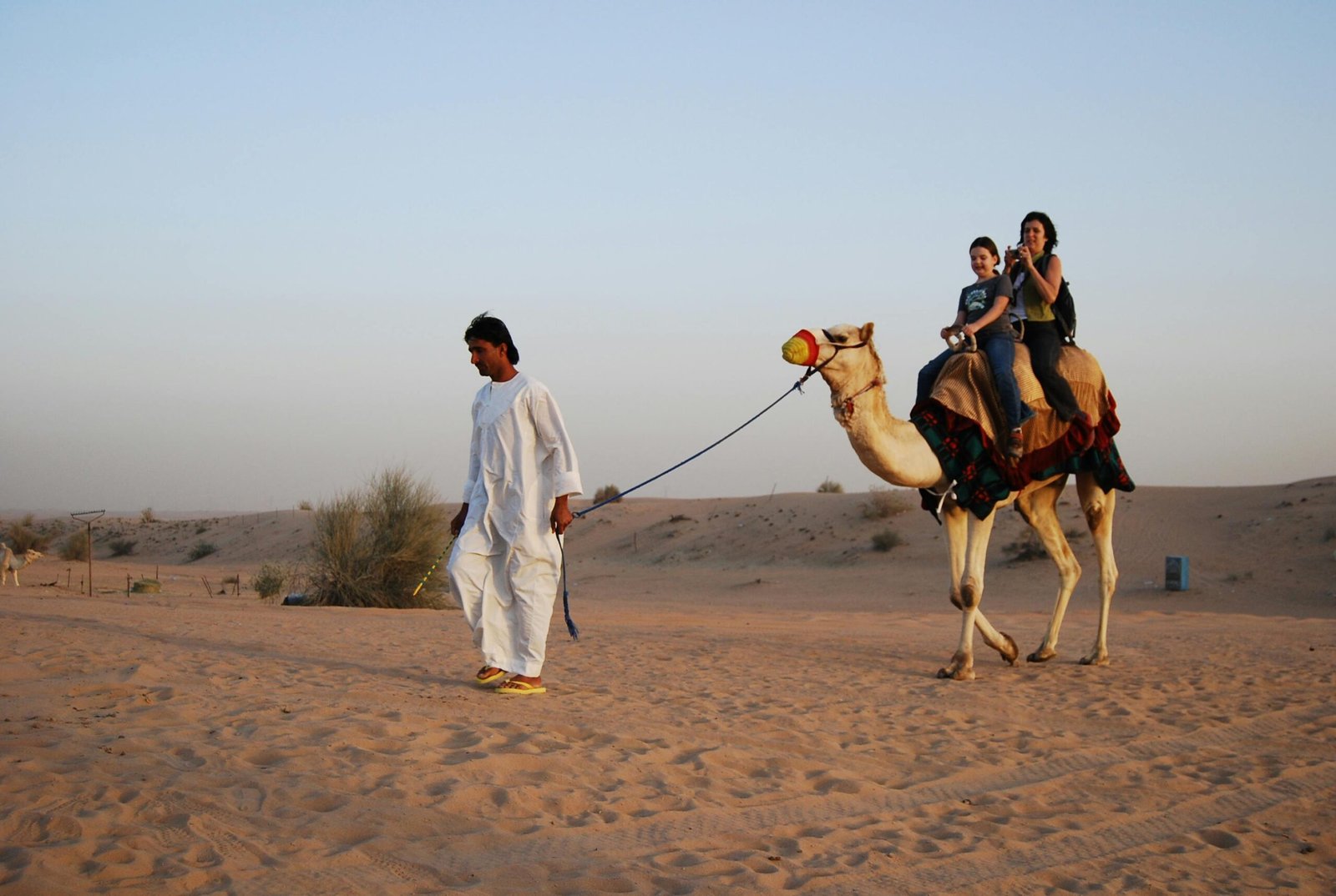 Golden dunes of Dubai desert safari at sunset, featuring camel riding and traditional experiences, capturing adventure and cultural immersion.