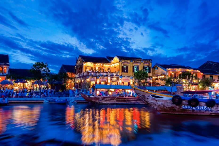 Colorful lanterns glowing at night over the river in the ancient town of Hoi An, one of the best cities to visit in Vietnam.