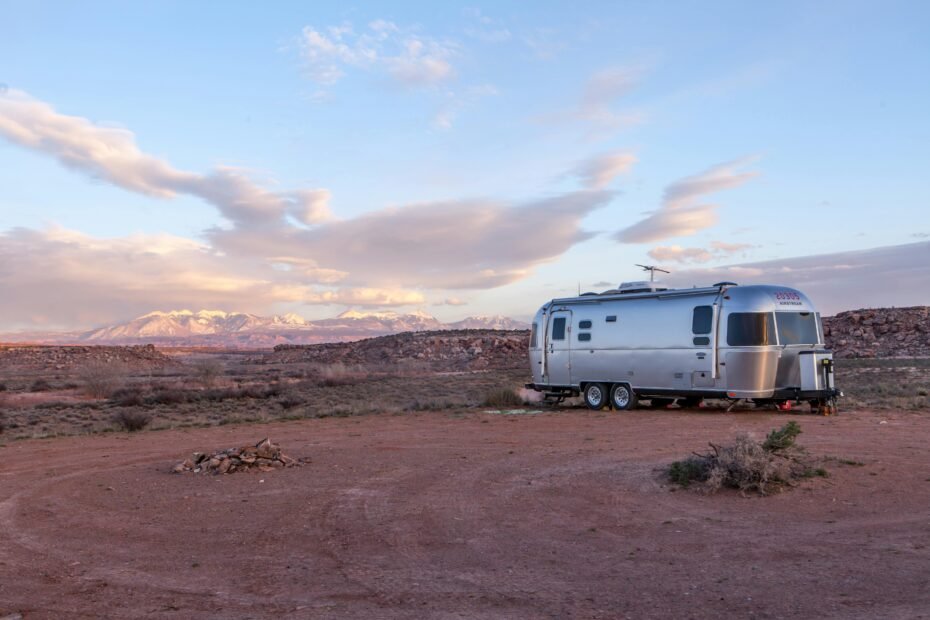 A modern two-stage automatic changeover propane regulator attached to dual propane tanks on a travel trailer, symbolizing essential safety and reliable fuel supply for RV camping and adventures.