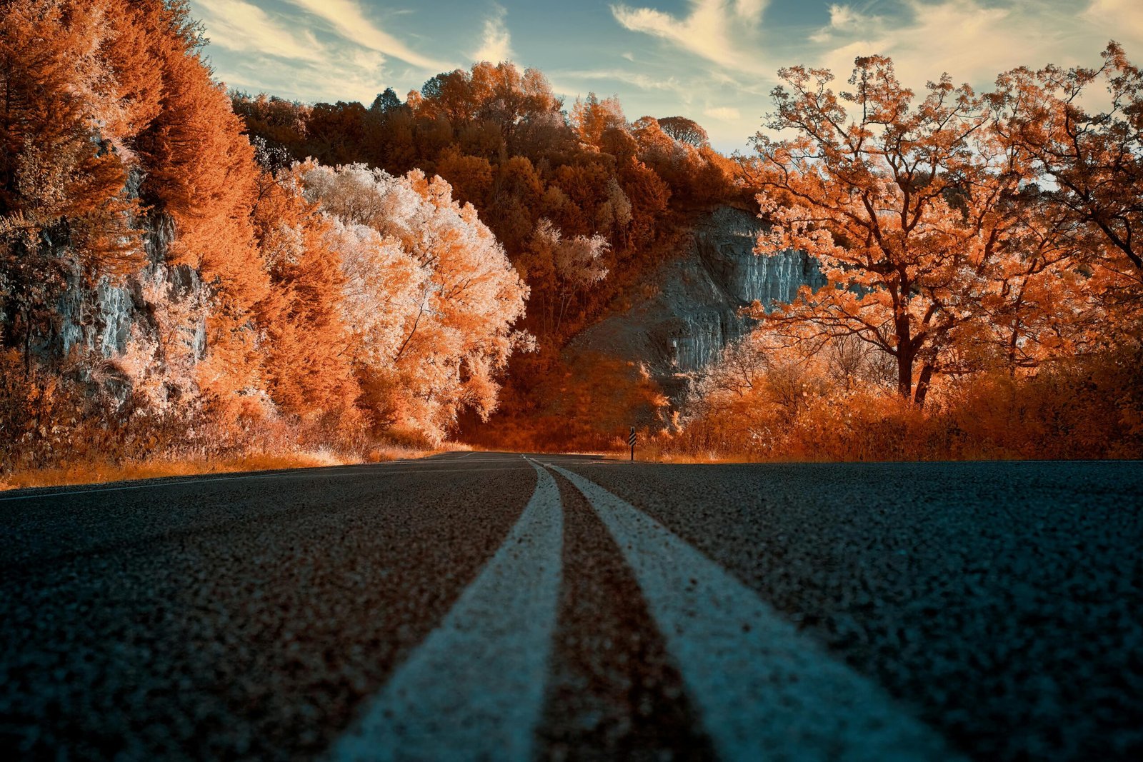 Vibrant fall foliage on a scenic road in the USA, representing the best places to travel in October for a memorable autumn trip.