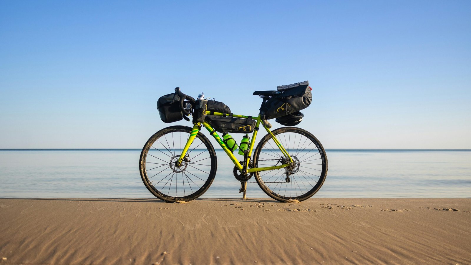 A cyclist pulling a black, wheeled bike travel bag through a bustling airport terminal, ready for an international cycling adventure.