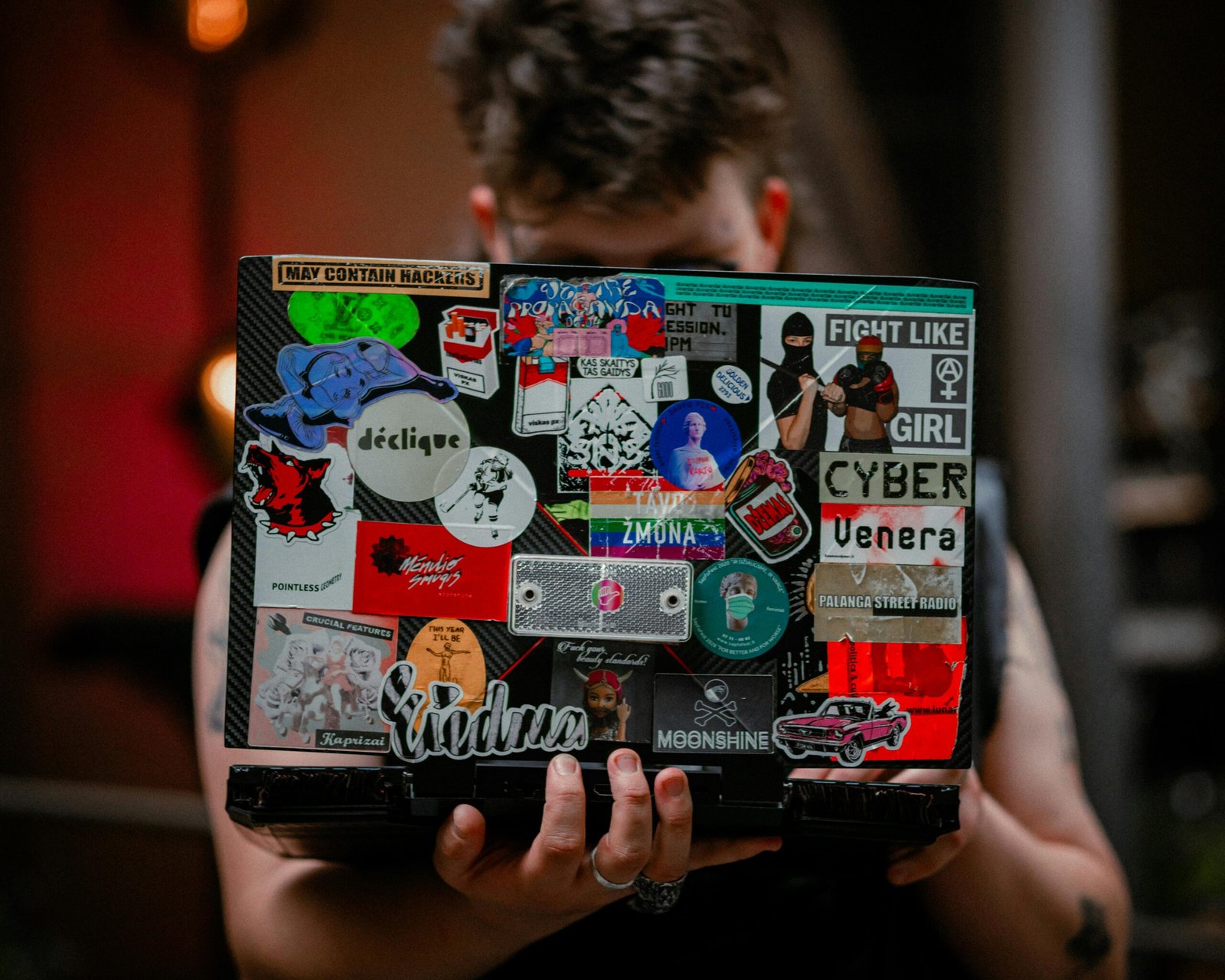 A close-up of a personalized suitcase, laptop, and water bottle adorned with a vibrant collection of unique travel stickers, symbolizing adventures, cherished memories, and individual wanderlust.
