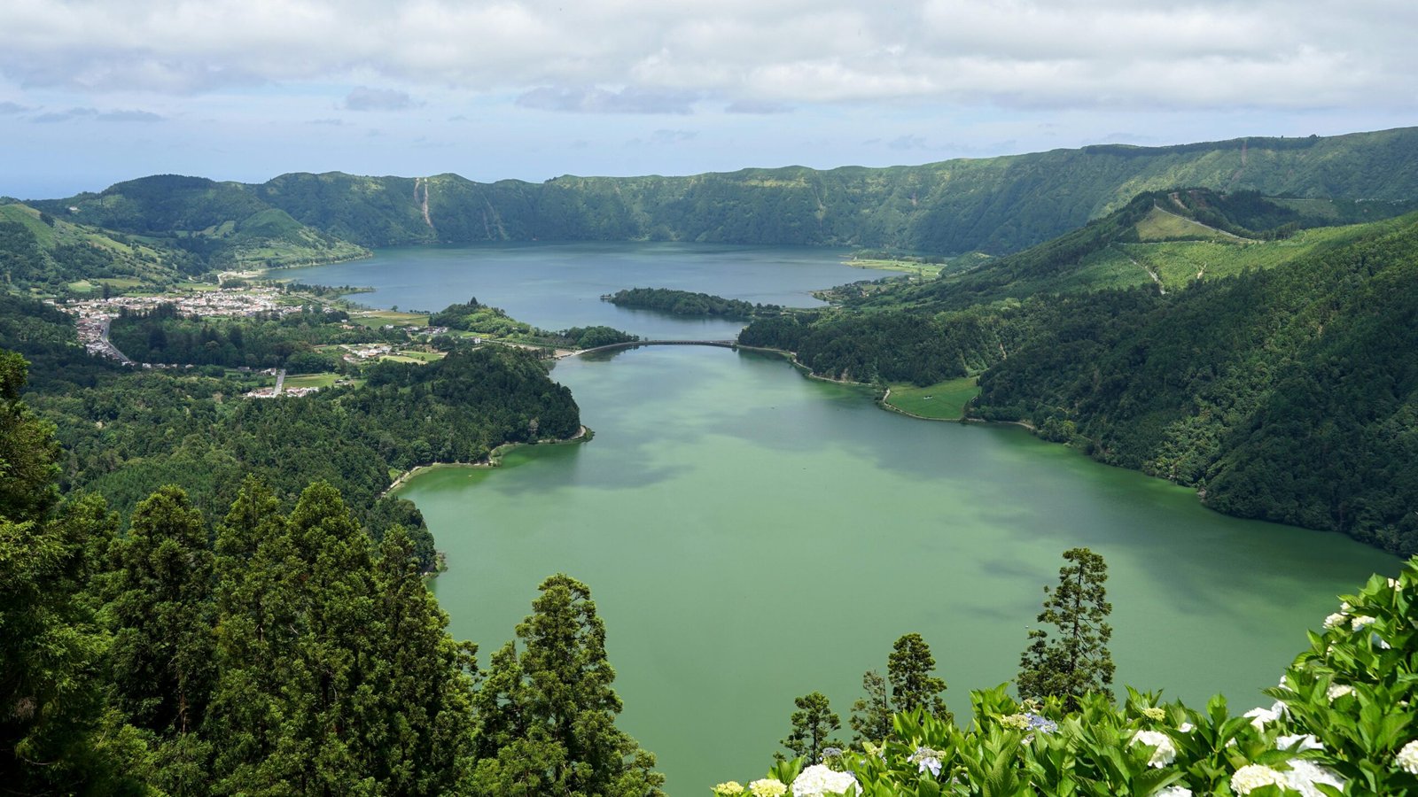 Panoramic view of lush green volcanic landscape with serene twin lakes in the Azores, ideal for exploring azores travel packages.