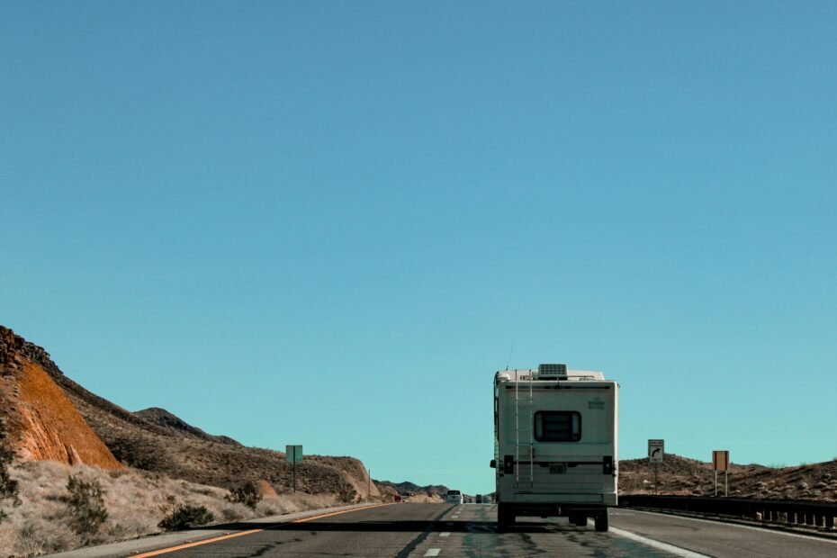 Secure travel trailer hitch connection on a modern RV being safely towed by a vehicle on a scenic highway, emphasizing stable towing for road trip adventures.