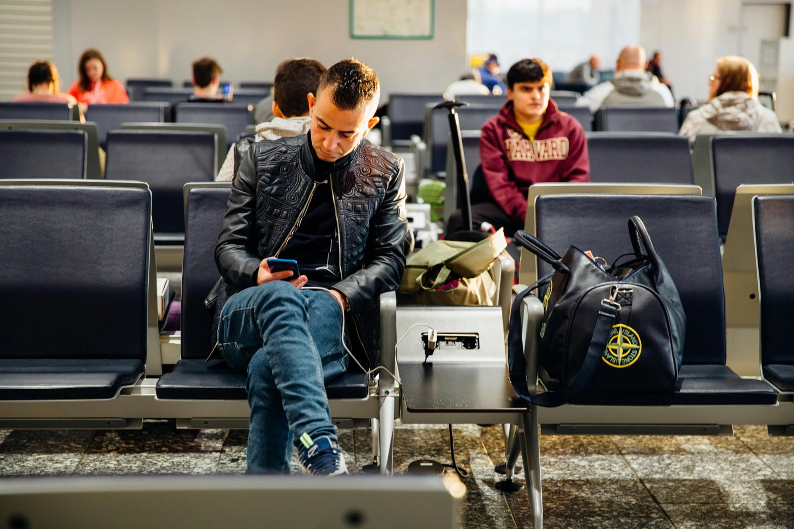 Parent with baby at airport using a durable infant car seat travel bag with wheels, ensuring protected and convenient family travel.