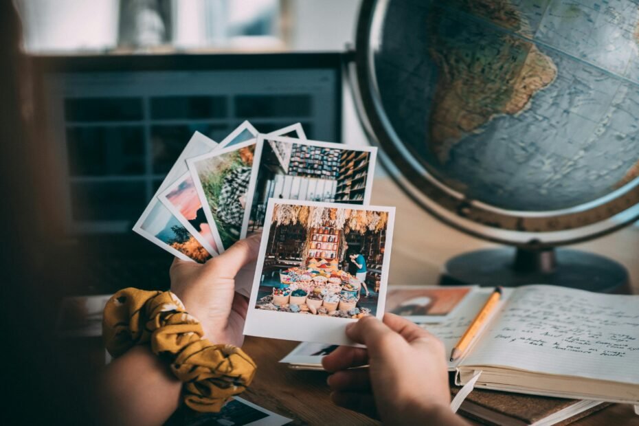 Person thoughtfully reviewing travel photos and notes in a journal, using post-trip evaluation to plan and improve future adventures and make every journey more memorable.
