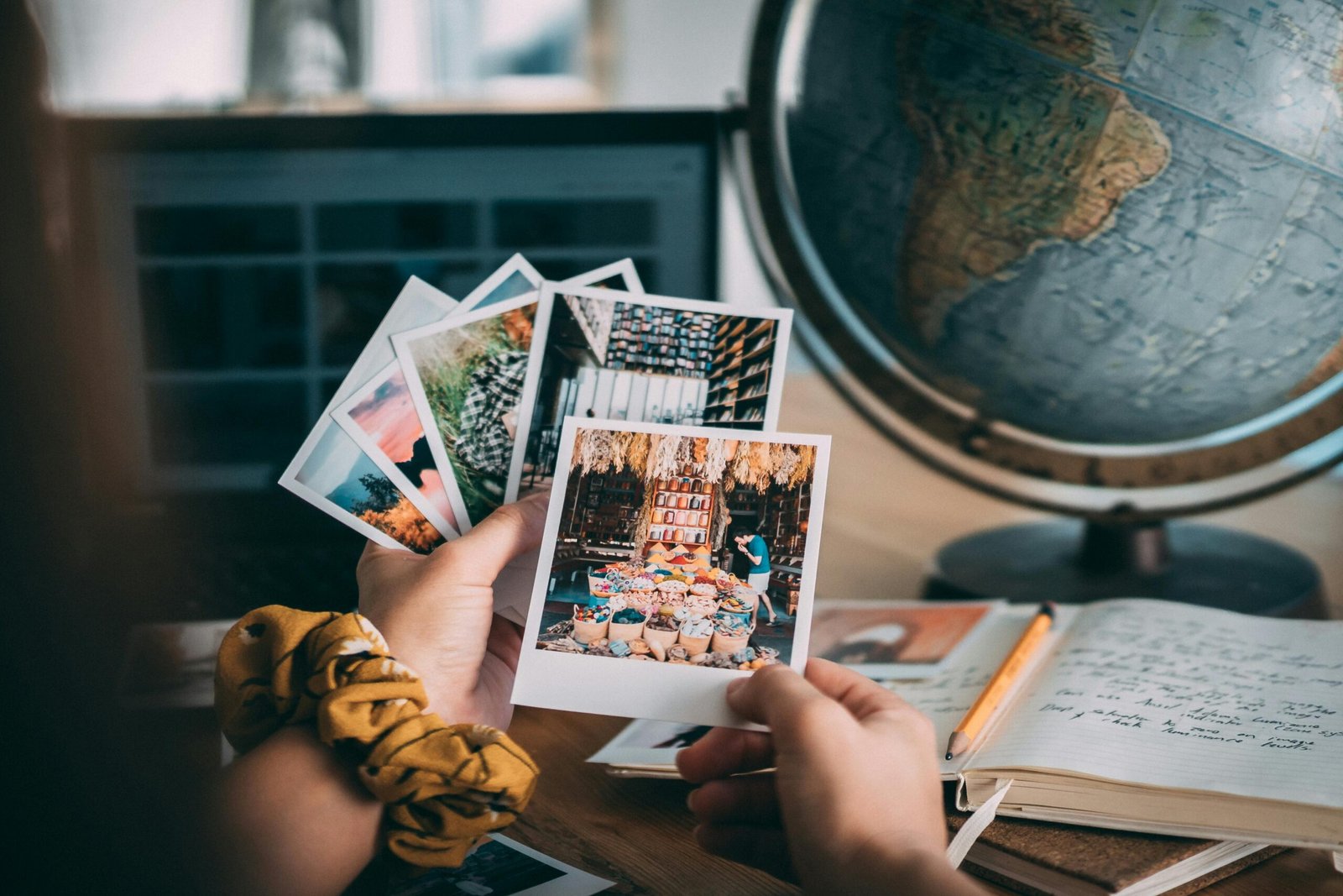 Person thoughtfully reviewing travel photos and notes in a journal, using post-trip evaluation to plan and improve future adventures and make every journey more memorable.