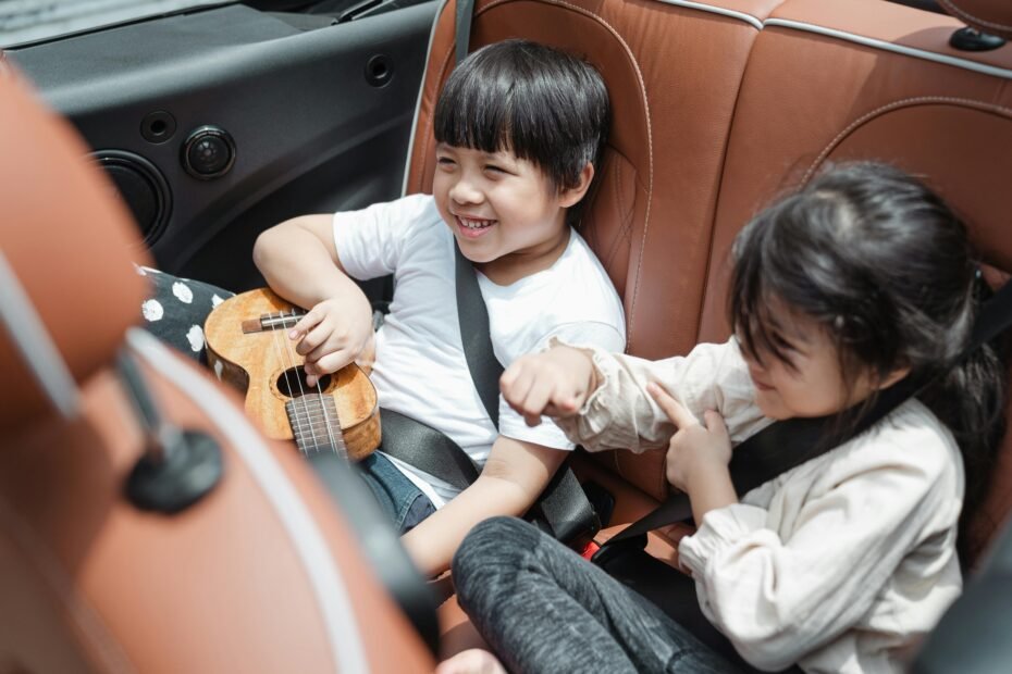 RideSafer travel vest on a smiling child in a car, showcasing a compact and portable child safety solution for stress-free family travel, rental cars, and carpooling.