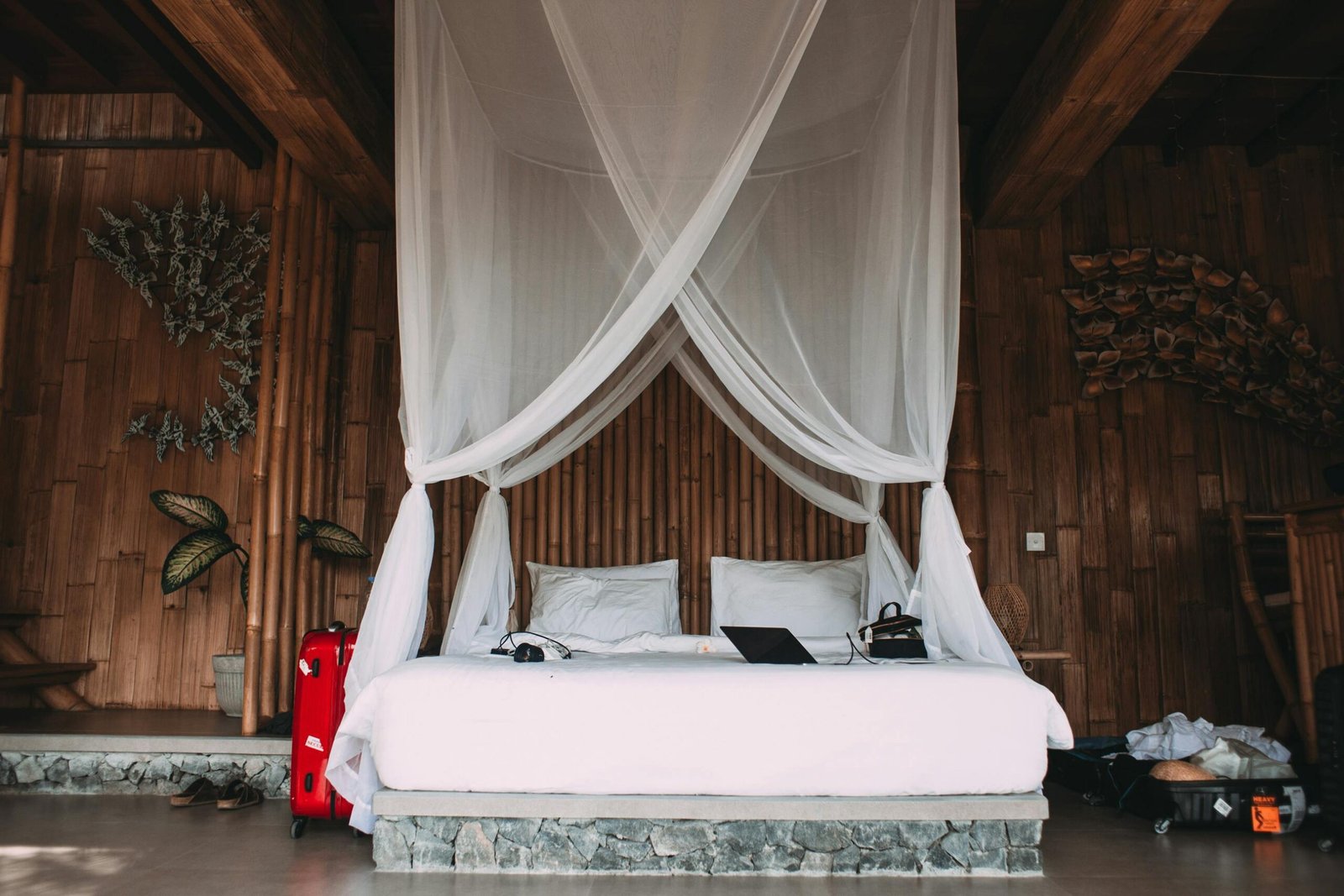 A pristine white traveling mosquito net gracefully draped over a bed in a tranquil tropical bedroom, providing essential insect protection and ensuring peaceful, disease-free sleep for travelers.