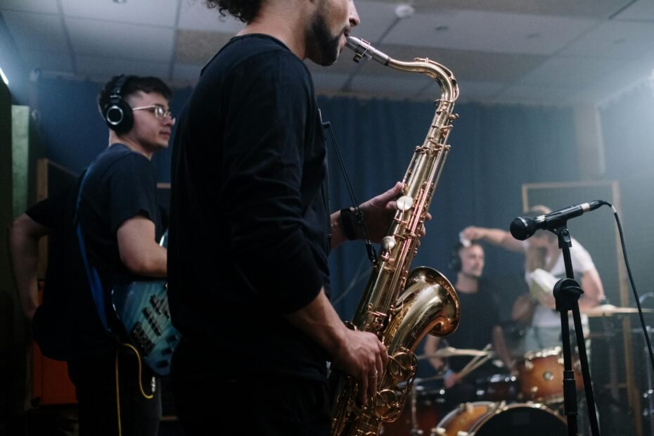 Travel Sax 2 electronic saxophone for silent practice, held by a musician wearing headphones in a portable setting. This compact MIDI controller allows saxophonists to practice anywhere, maintaining embouchure and finger memory without disturbing others.
