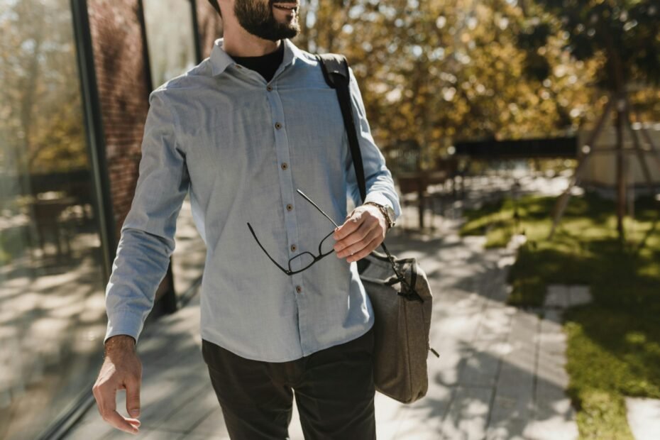 A stylish man in a modern airport terminal carrying a sleek, durable travel duffel bag, symbolizing efficient and sophisticated men's travel.