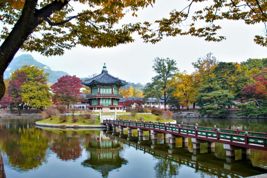 Scenic South Korean landscape adorned with vibrant autumn foliage and traditional buildings, representing the best time to visit for picturesque scenery.