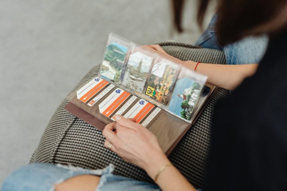 Hands artfully arranging travel photos, flight tickets, and maps onto a page of an open travel scrapbook, surrounded by pens and crafting supplies on a wooden table, symbolizing the creative process of preserving cherished travel memories.