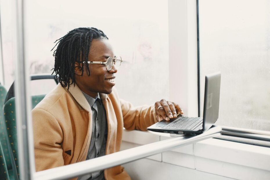 Happy travel professional smiling at their desk with travel elements, symbolizing a fulfilling career in a top travel agency with excellent benefits and growth opportunities.