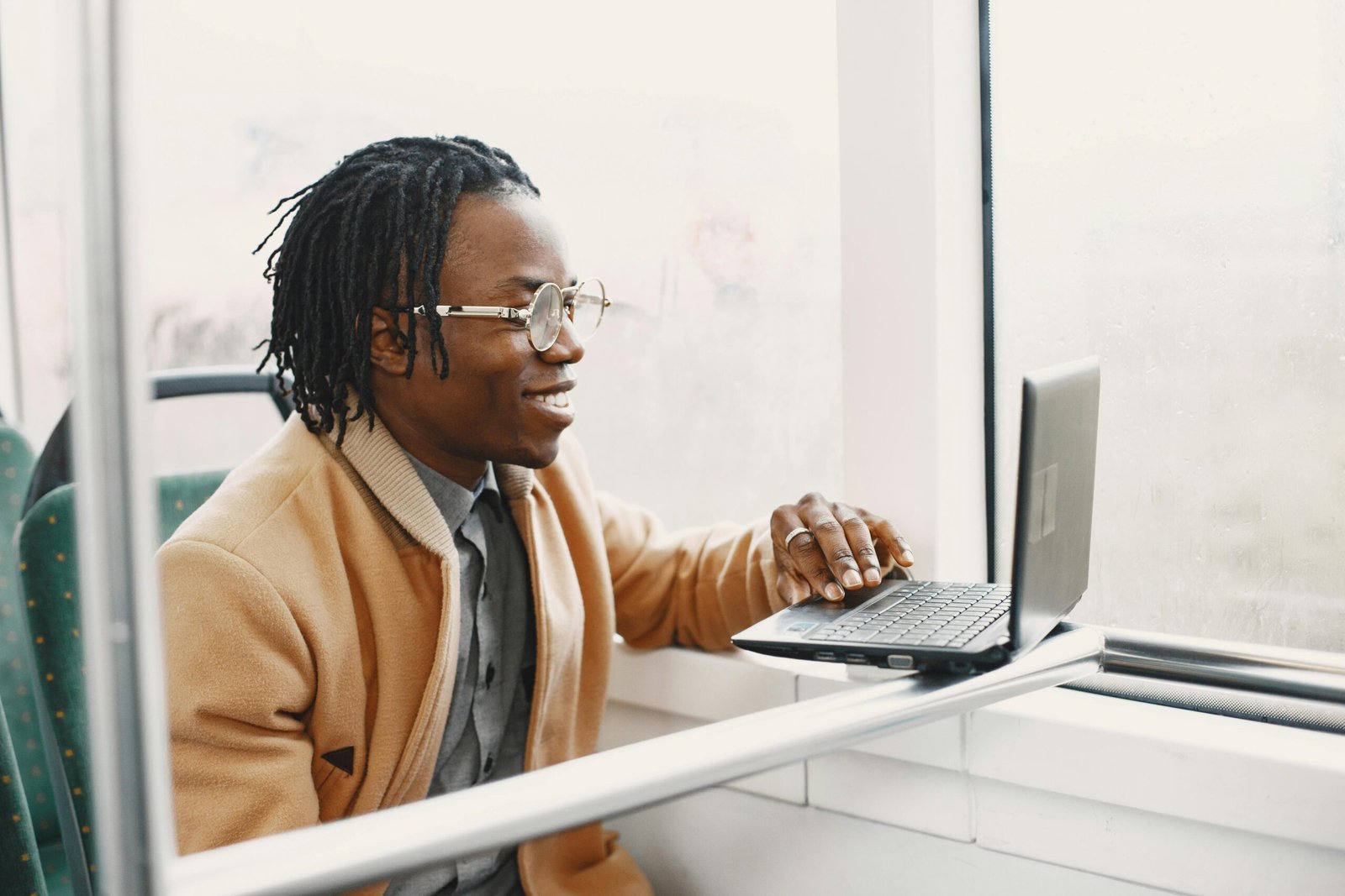 Happy travel professional smiling at their desk with travel elements, symbolizing a fulfilling career in a top travel agency with excellent benefits and growth opportunities.