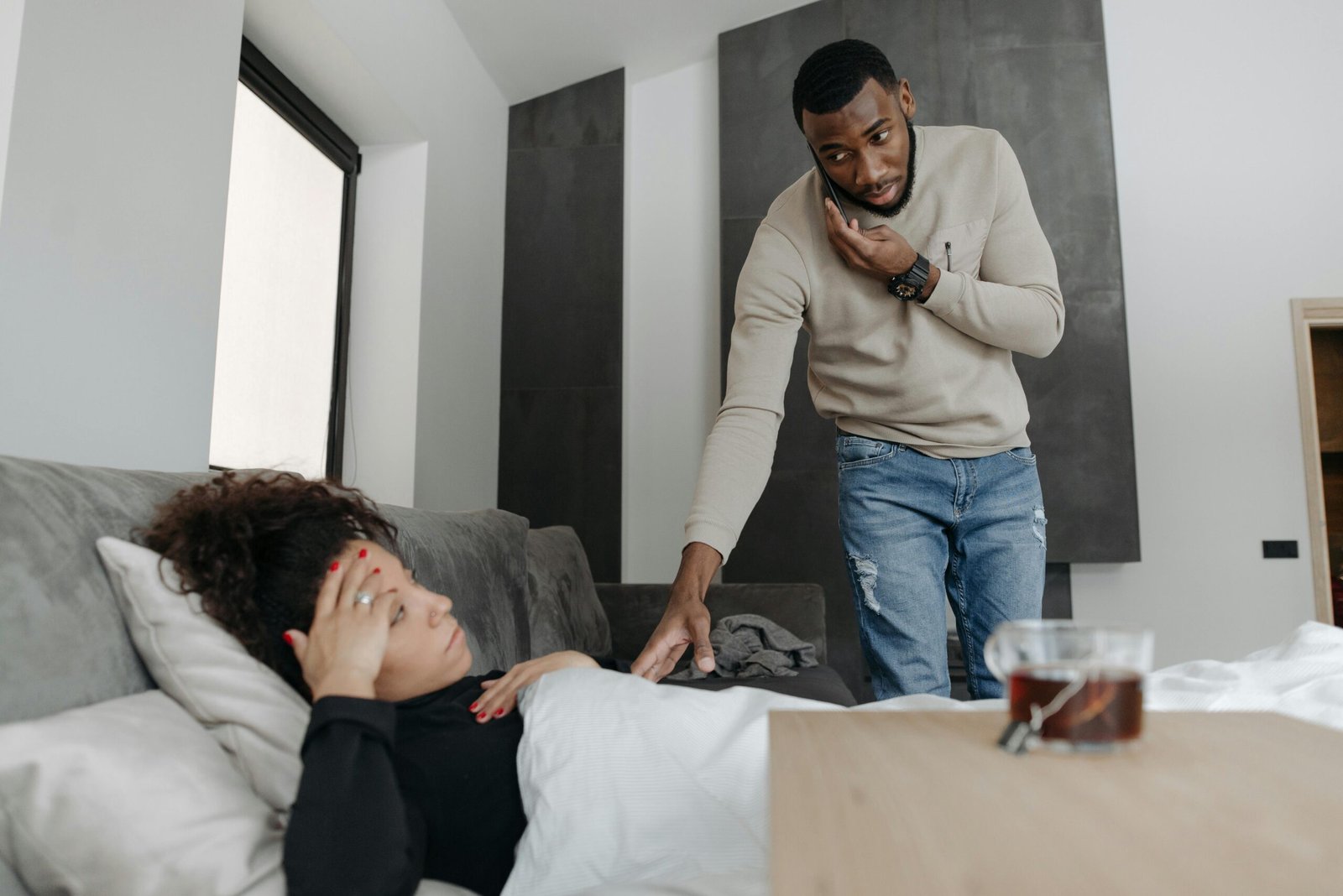 A skilled traveling phlebotomist wearing blue scrubs carefully performing a blood draw on a smiling patient's arm, illustrating dedicated mobile healthcare and the appealing flexibility of traveling phlebotomy jobs.