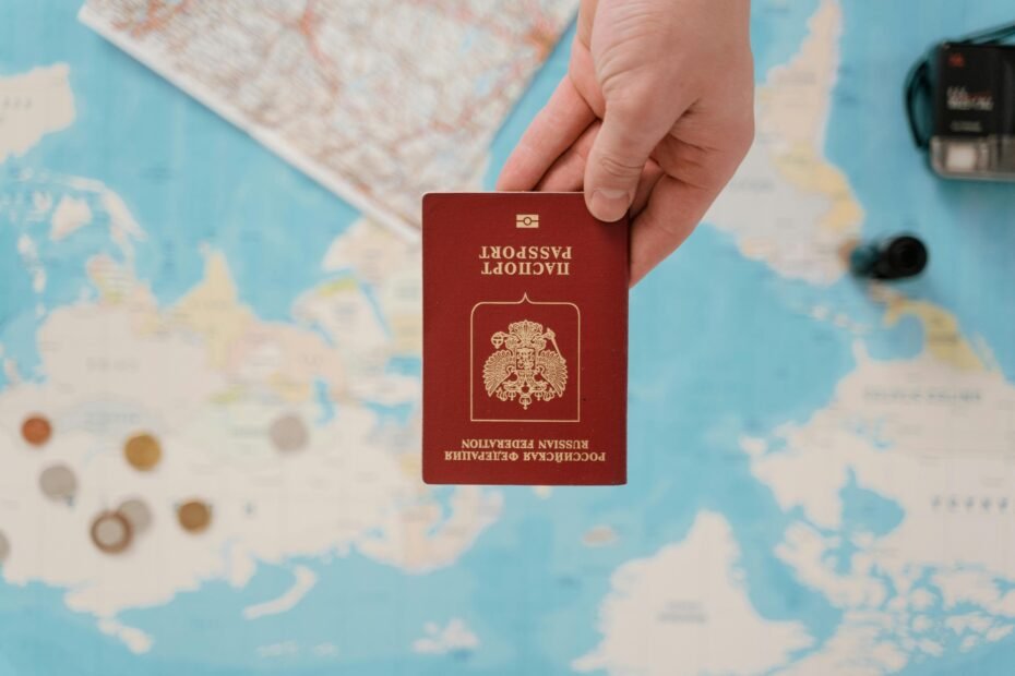 A hand holding a passport being examined or stamped 'Denied' over a blurred world map, symbolizing the significant international travel restrictions and entry challenges faced by individuals with a felony or criminal record due to strict immigration laws.