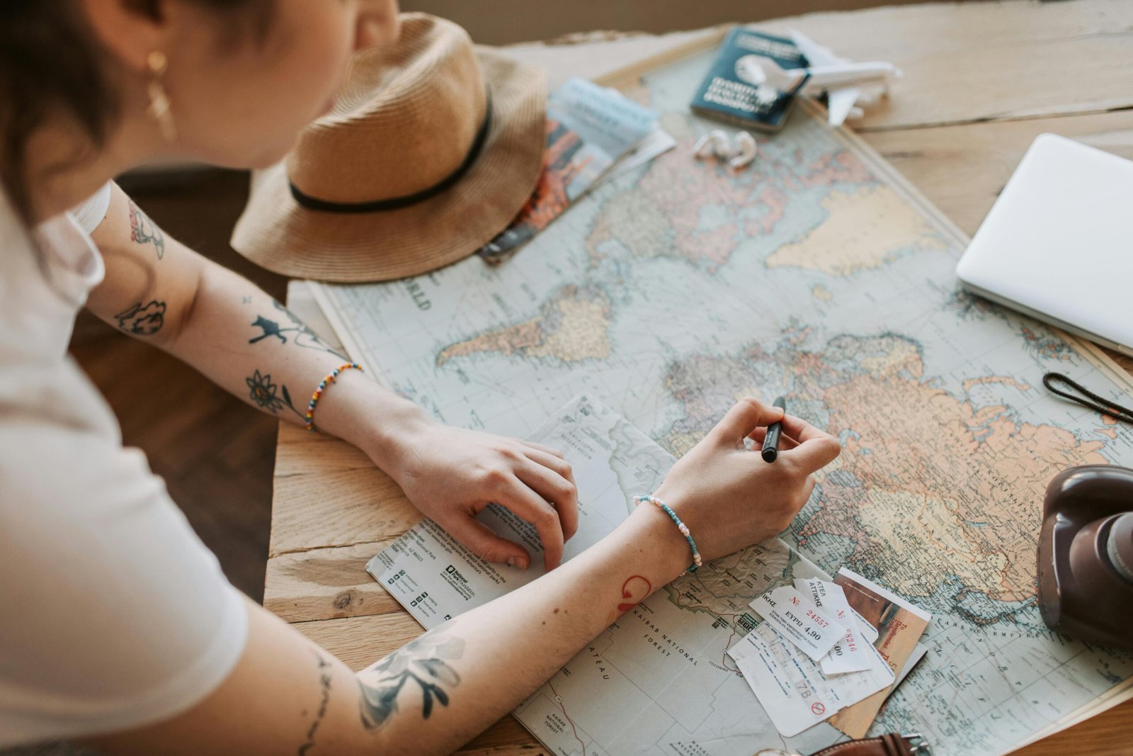 Diverse young students smiling and collaborating over a map and laptop, symbolizing the simplified, budget-friendly, and exciting international travel experiences offered by a student travel bureau.