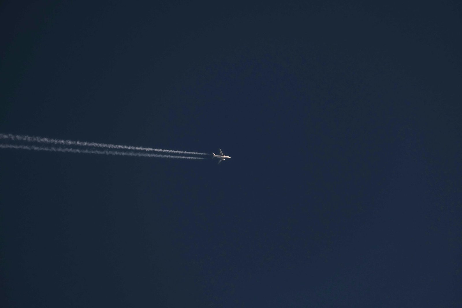 A modern commercial jet airplane flying at high cruising speed above the clouds, illustrating the impressive speeds of air travel and the efficiency of various aircraft types.