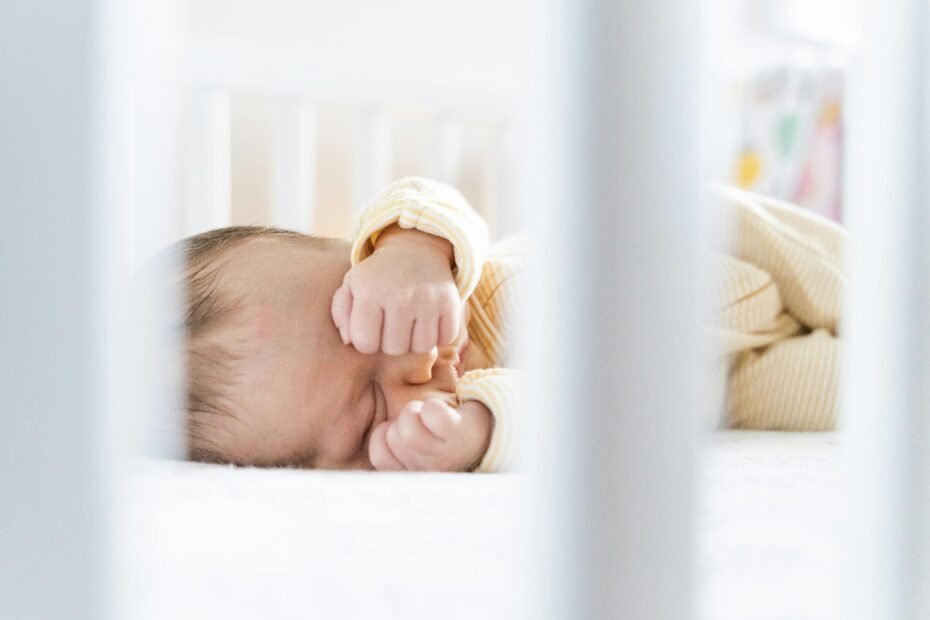 Baby sleeping peacefully in a Newton Travel Crib, highlighting its 100% breathable and portable design for safe infant travel.