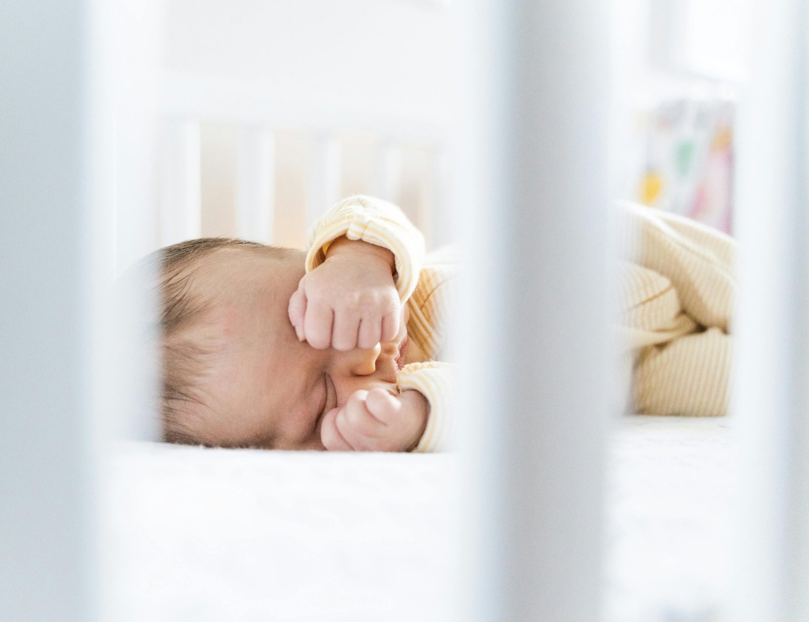 Baby sleeping peacefully in a Newton Travel Crib, highlighting its 100% breathable and portable design for safe infant travel.