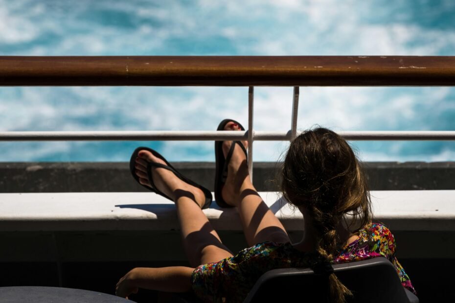 Happy person on a cruise ship deck looking at the calm ocean horizon, symbolizing effective seasickness prevention for an enjoyable and smooth cruise vacation.