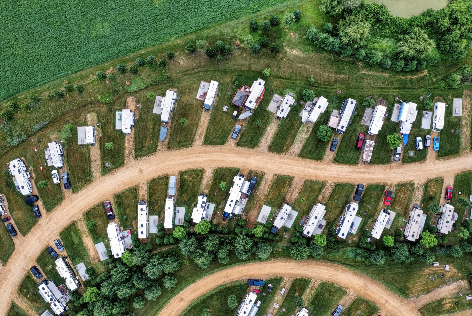 Shady Acres Travel Park featuring modern RVs on spacious, tree-lined sites, with guests enjoying the welcoming community and natural surroundings, emphasizing comfort and top-tier amenities for a memorable stay.