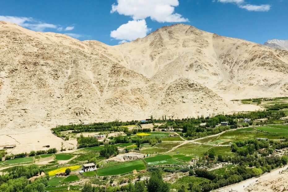 Panoramic view of the majestic Machu Picchu ancient Inca citadel under a clear blue sky, surrounded by vibrant green Andes mountains in Peru, conveying the ideal travel conditions of the shoulder season.