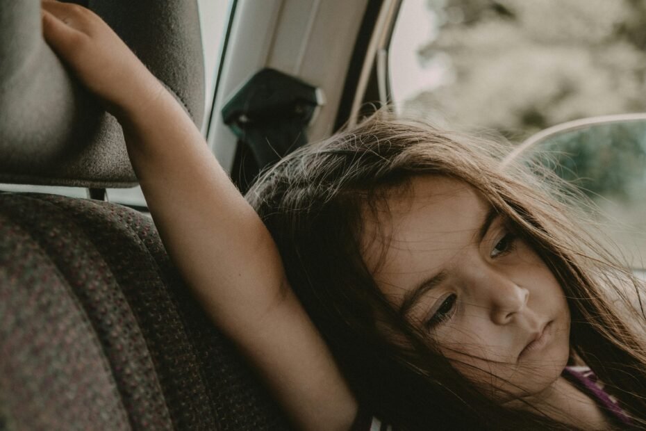 Child safely seated in a lightweight travel car seat at an airport, highlighting convenient and FAA-approved car seat options for family travel.