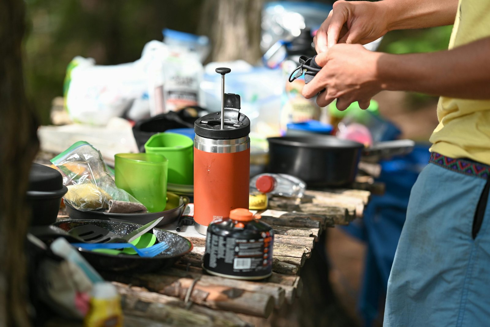 Traveler enjoying fresh coffee brewed with a travel French press in a scenic outdoor environment, highlighting portable coffee solutions for adventure.