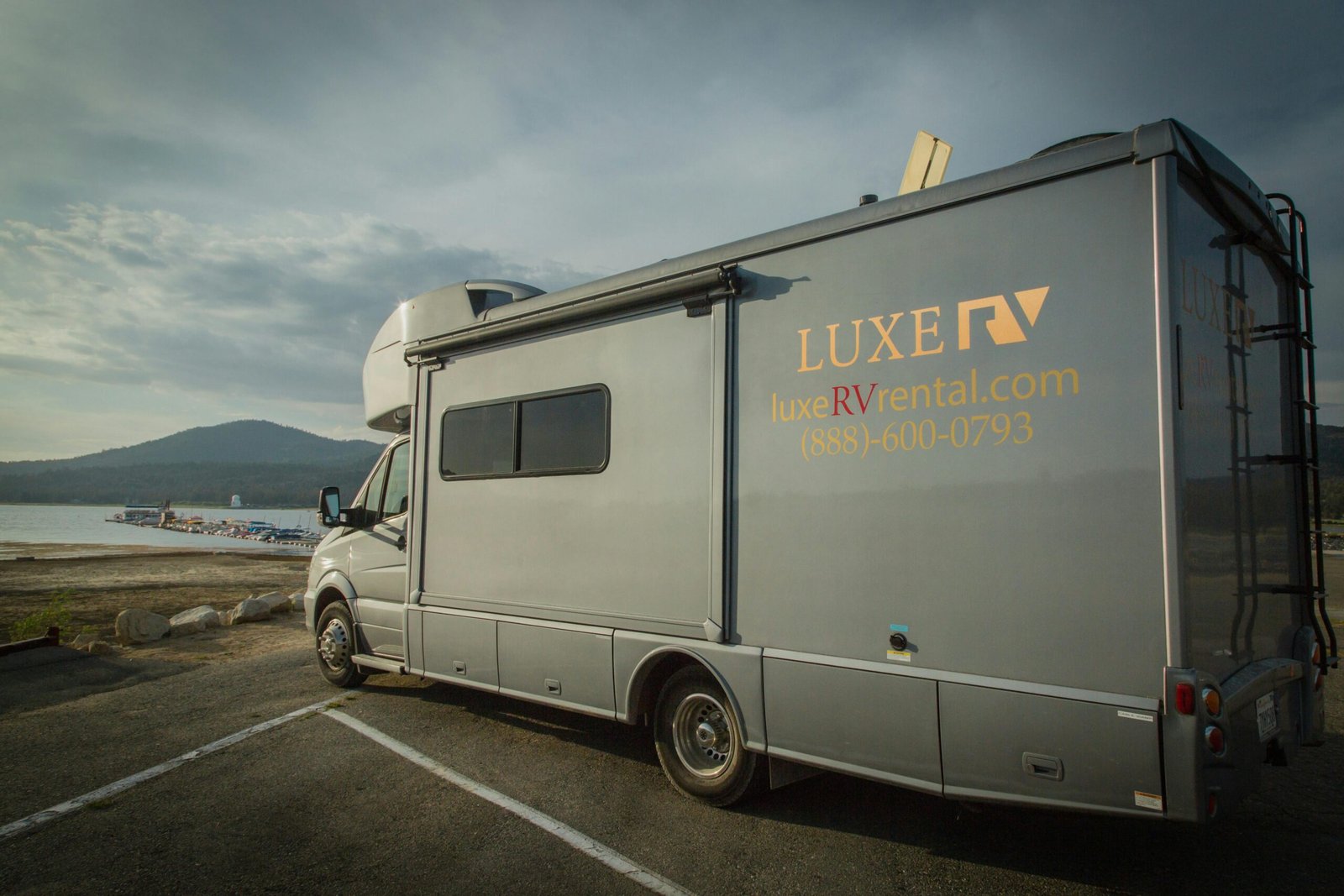 Grand Design Imagine travel trailer at a beautiful scenic campsite, representing luxury, lightweight design, and four-season comfort for unforgettable RV adventures.