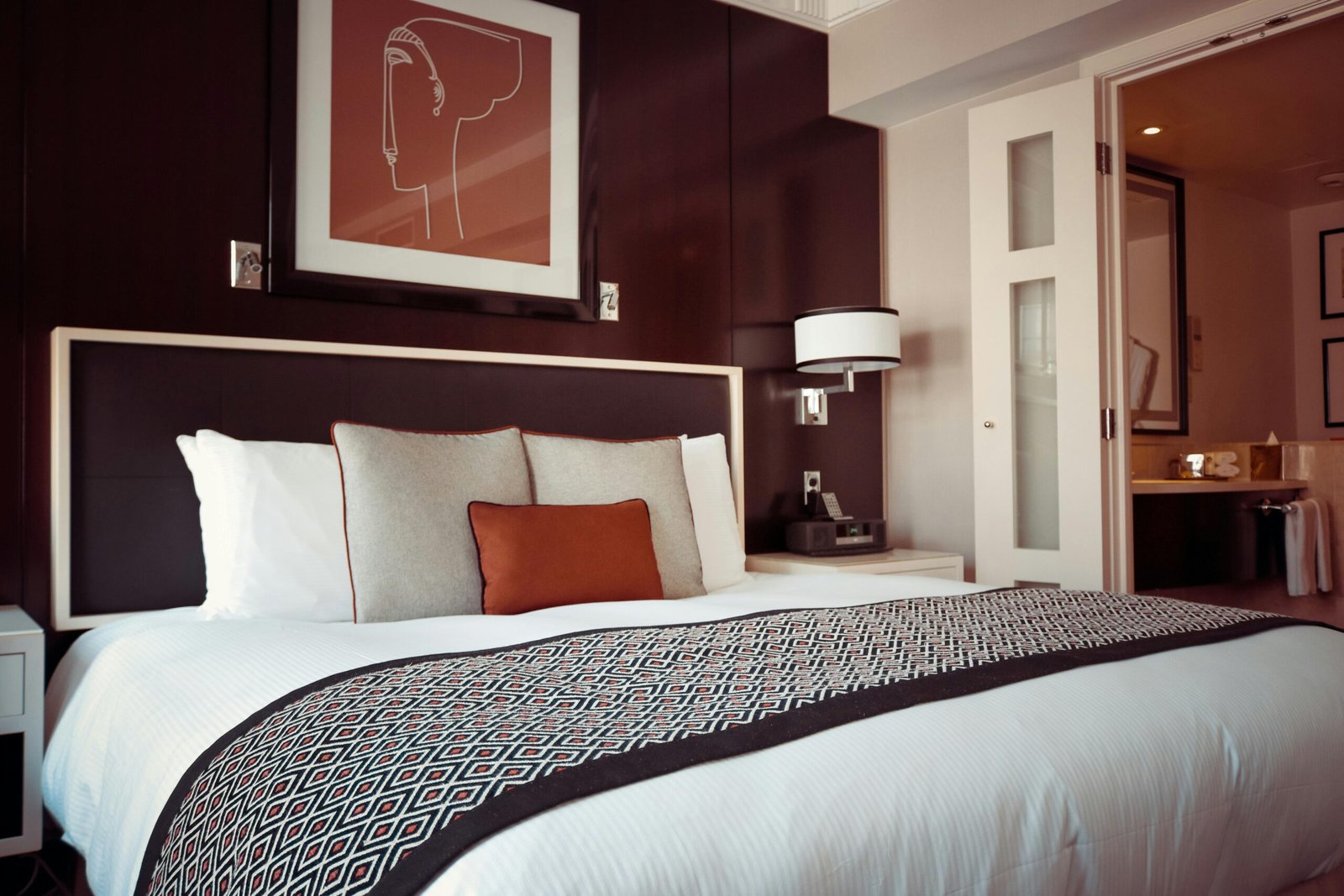 A compact portable carbon monoxide detector on a hotel room nightstand, providing essential travel safety and peace of mind against invisible dangers.