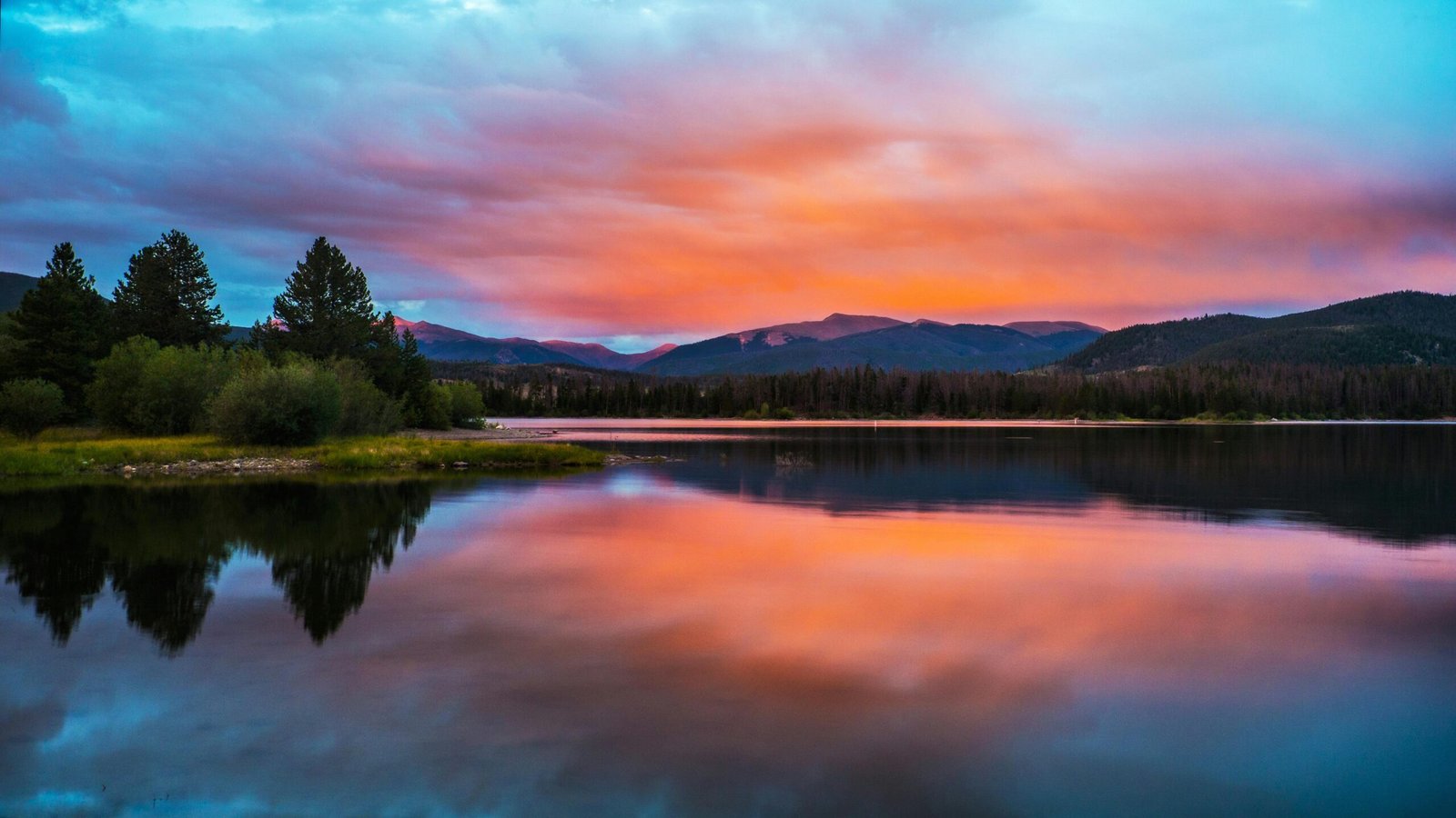 Scenic Colorado landscape showcasing majestic Rocky Mountains, a vibrant town nestled in foothills, and clear blue skies, representing diverse outdoor adventures and top travel destinations.