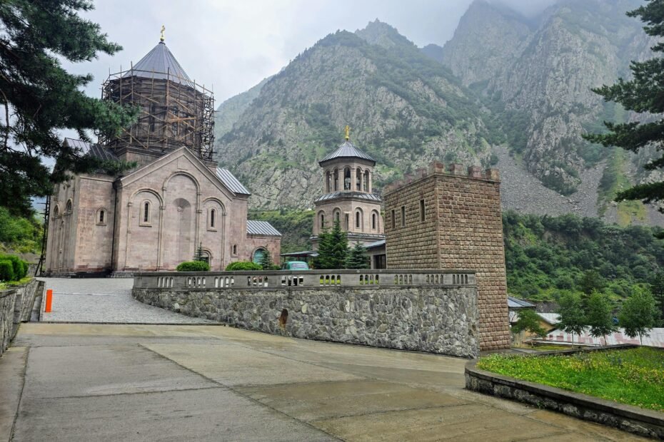 Iconic Gergeti Trinity Church nestled in the majestic Caucasus Mountains, symbolizing the historical and adventurous experiences offered by Georgia travel packages.
